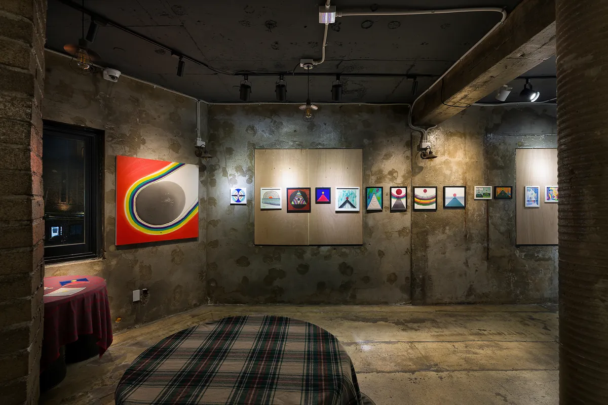 Installation view — main room with works on concrete and plywood walls