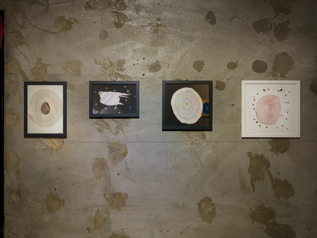 Installation view — four small framed works on a concrete wall