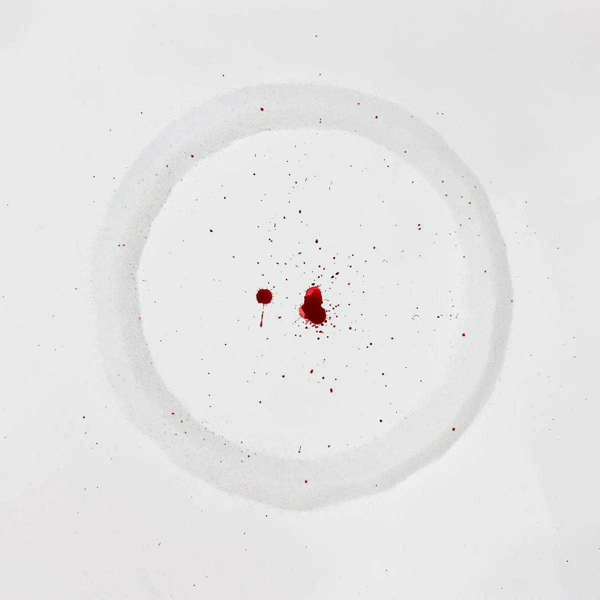 One Before Zero — white circular relief marked with drops of red
